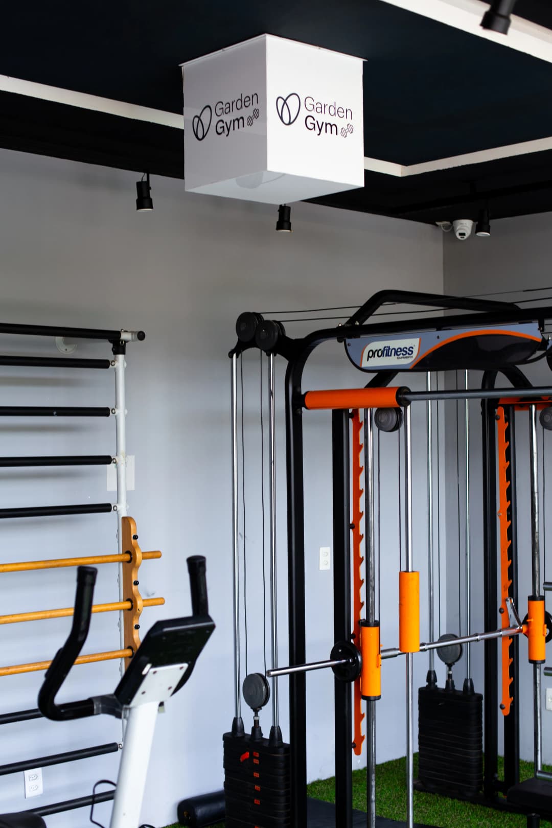 Equipamentos de musculação com pesos livres e bancos ajustáveis em ambiente iluminado.