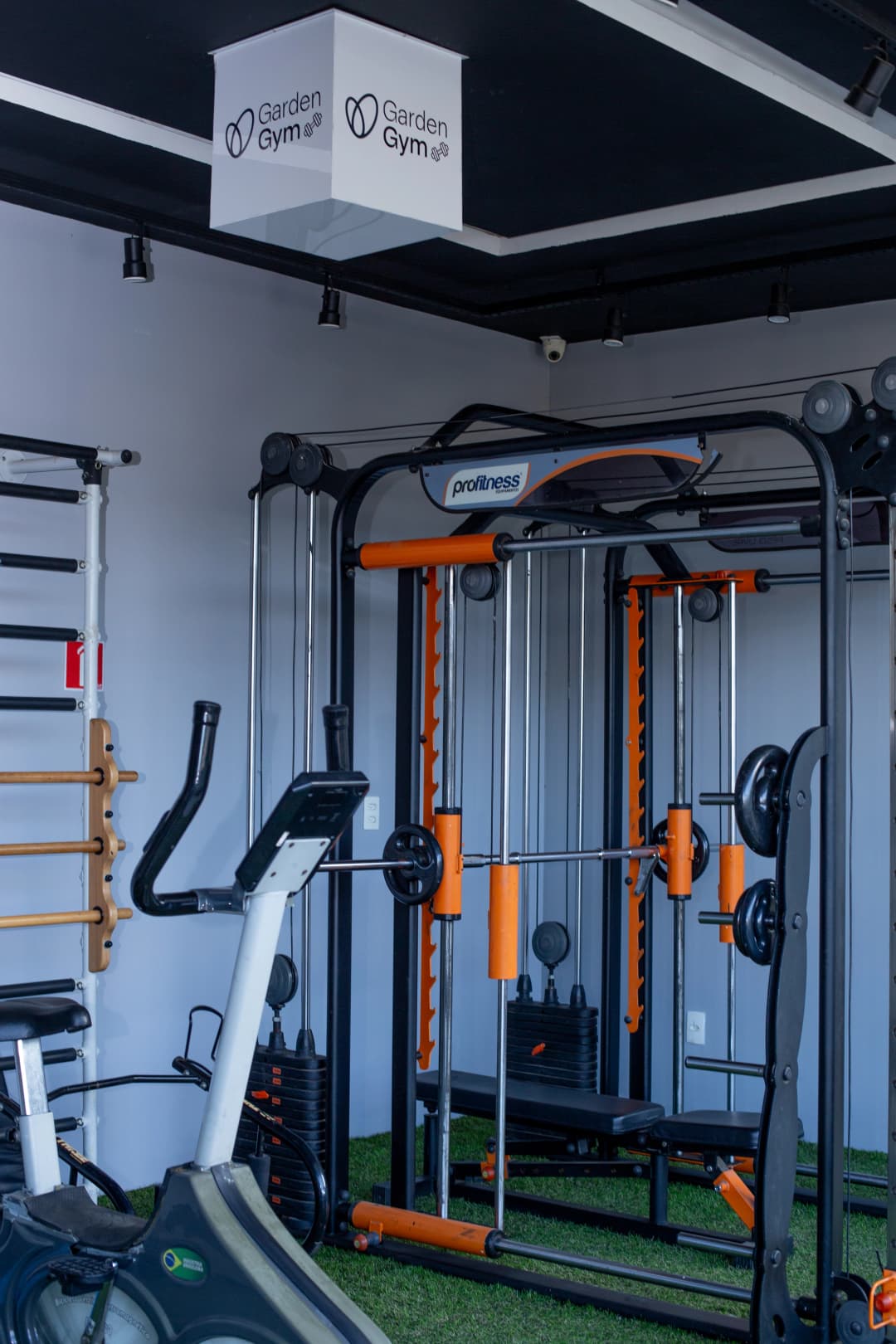 Vista geral da academia do hotel com estação de musculação e esteiras.