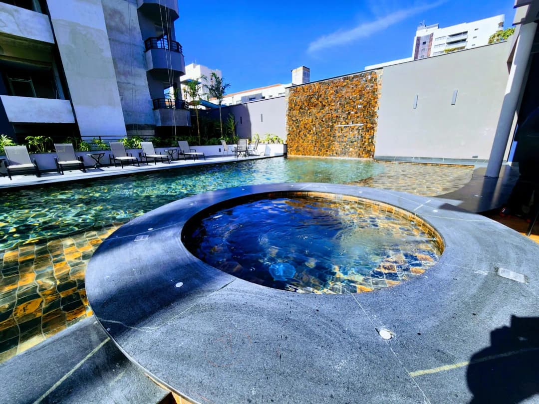 Vista da piscina climatizada rodeada por vegetação